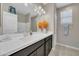 Bright bathroom featuring a vanity, ample counterspace, storage, modern sink fixtures, and decorative flower arrangement at 38150 W San Sisto Ave, Maricopa, AZ 85138