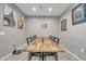 Modern dining room featuring a long wood table, seating for eight, and stylish wall art at 38150 W San Sisto Ave, Maricopa, AZ 85138