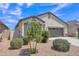 Well-maintained home with desert landscaping, including a young tree and flowering bushes at 38150 W San Sisto Ave, Maricopa, AZ 85138