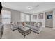 Comfortable living room featuring a large gray sectional sofa and modern decor at 38150 W San Sisto Ave, Maricopa, AZ 85138
