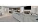 Open-concept living area featuring a gray sofa and view into the kitchen at 38150 W San Sisto Ave, Maricopa, AZ 85138