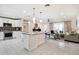 Open-concept kitchen with stainless steel appliances, a central island, flowing into a cozy living area with ample natural light at 3824 N 50Th Pl, Phoenix, AZ 85018