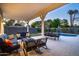 Cozy covered patio with comfortable seating, dining area, and view of the lush backyard and sparkling pool at 3824 N 50Th Pl, Phoenix, AZ 85018
