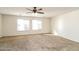 Spacious bedroom featuring neutral carpet, ceiling fan, and large windows for ample natural light at 409 E Saddle Way, San Tan Valley, AZ 85143
