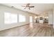 Open living room with wood-look floors that flows into the kitchen with stainless appliances at 409 E Saddle Way, San Tan Valley, AZ 85143