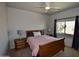 Charming bedroom with ceiling fan, natural light from window, with nightstands on either side of bed at 44236 W Adobe Cir, Maricopa, AZ 85139