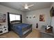 Cozy bedroom with a large bed, modern ceiling fan, and a window with black out curtains at 44236 W Adobe Cir, Maricopa, AZ 85139