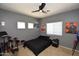 Cozy bedroom with neutral paint, ceiling fan and a view of the front yard at 44236 W Adobe Cir, Maricopa, AZ 85139