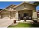 Inviting home featuring a charming front porch and well-manicured lawn and three-car garage at 44236 W Adobe Cir, Maricopa, AZ 85139