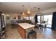 Open-concept kitchen with stainless steel appliances and an island with bar seating overlooking living room at 44236 W Adobe Cir, Maricopa, AZ 85139