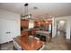 A kitchen with stainless steel appliances, a large kitchen island, tile floors, and a wood dining room table at 44236 W Adobe Cir, Maricopa, AZ 85139