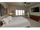 Main bedroom featuring a ceiling fan, plantation shutters, carpeting, and contemporary decor at 44236 W Adobe Cir, Maricopa, AZ 85139