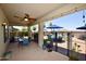 Covered patio with ceiling fan, outdoor table and chairs, and view of the pool and putting green at 44236 W Adobe Cir, Maricopa, AZ 85139