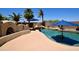 A backyard pool with rock waterfall feature, built in barbeque, and desert landscaping at 44236 W Adobe Cir, Maricopa, AZ 85139