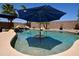Backyard pool with waterfall feature, stone island and in-pool umbrella stand at 44236 W Adobe Cir, Maricopa, AZ 85139