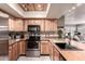 Updated kitchen features wood cabinets, stainless steel appliances, and unique lighting at 4441 W Windrose Dr, Glendale, AZ 85304