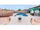 Outdoor swimming pool with diving board, framed by brick and stone accents with a covered seating area nearby at 4441 W Windrose Dr, Glendale, AZ 85304
