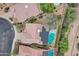 Birds-eye view of a home featuring a private pool, desert landscaping, and rooftop solar panels at 4449 E Rancho Caliente Dr, Cave Creek, AZ 85331
