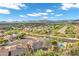 This aerial view highlights homes with backyard pools, desert landscaping, and mountain views in a suburban neighborhood at 4449 E Rancho Caliente Dr, Cave Creek, AZ 85331
