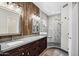 A luxurious main bathroom with dual vanities, mirrors, wood paneling, and a tiled walk-in shower at 4449 E Rancho Caliente Dr, Cave Creek, AZ 85331