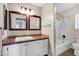 Bathroom with double mirrors, neutral cabinets, and tub-shower combination at 4449 E Rancho Caliente Dr, Cave Creek, AZ 85331