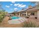 A beautiful backyard features a sparkling pool with natural rock accents and a covered patio, perfect for relaxing at 4449 E Rancho Caliente Dr, Cave Creek, AZ 85331