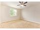 This bedroom features carpeted floors, a ceiling fan, and natural light from a window at 4853 S Charger --, Mesa, AZ 85212