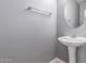 Cozy bathroom featuring a pedestal sink, a towel bar, and a round mirror at 5104 W Fulton St, Phoenix, AZ 85043