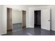 Bedroom with gray tile floor, mirrored closet doors, and an open doorway, all illuminated by natural light at 5104 W Fulton St, Phoenix, AZ 85043