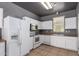 Well-lit kitchen boasts a refrigerator, oven, microwave, and ample white cabinetry at 5104 W Fulton St, Phoenix, AZ 85043