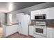 The kitchen includes a refrigerator, oven, microwave, and plenty of cabinet space at 5104 W Fulton St, Phoenix, AZ 85043