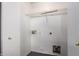 A laundry room features white walls, with plumbing connections and wire shelving for easy organization at 5104 W Fulton St, Phoenix, AZ 85043