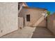 Enclosed patio area with tan stucco walls, a small gate, and a concrete slab at 5104 W Fulton St, Phoenix, AZ 85043