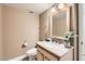 Cozy powder room with a wooden vanity, updated fixtures, and neutral decor at 5166 N 83Rd St, Scottsdale, AZ 85250