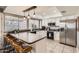 Bright kitchen featuring a breakfast bar with barstools and modern appliances, including stainless steel refrigerator at 5166 N 83Rd St, Scottsdale, AZ 85250