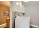 Laundry room featuring a front-loading washer and dryer, and overhead storage cabinets at 5166 N 83Rd St, Scottsdale, AZ 85250