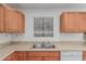 Kitchen with wooden cabinets, double stainless steel sink, window, and linoleum flooring at 560 E San Pedro Ave, Gilbert, AZ 85234