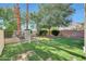 Lush backyard with manicured lawn, mature trees, and decorative fencing at 5726 W Park View Ln, Glendale, AZ 85310