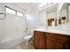 Bright bathroom featuring a shower-tub combination, wooden vanity and ceramic tile floors at 5726 W Park View Ln, Glendale, AZ 85310