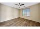 Cozy bedroom with a ceiling fan, wood floors, window with blinds, and a serene ambiance at 5726 W Park View Ln, Glendale, AZ 85310