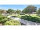 Beautiful community park with lush green grass, mature trees, a sidewalk, and park benches at 5726 W Park View Ln, Glendale, AZ 85310