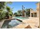Beautiful outdoor pool with a stone surround, integrated spa, and palm trees at 5726 W Park View Ln, Glendale, AZ 85310