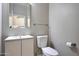 Modern powder room with a white vanity, framed mirror, toilet, and neutral paint at 5726 W Park View Ln, Glendale, AZ 85310