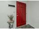 Interior view of a bright red door, stylish tile flooring, and a decorative potted plant at 601 E Palo Verde Dr # 27, Phoenix, AZ 85012