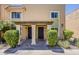 Close up view of condo exterior with updated neutral paint, manicured bushes, and desert landscaping at 601 E Palo Verde Dr # 27, Phoenix, AZ 85012