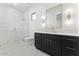 Bright bathroom with white marble shower, dark vanity, and gold fixtures at 6147 E Desert Cove Ave, Scottsdale, AZ 85254