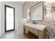 Modern bathroom featuring tiled accent wall and wood vanity with vessel sink at 6147 E Desert Cove Ave, Scottsdale, AZ 85254