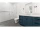 Bathroom showcasing a glass shower, blue vanity, and a lighted mirror at 6147 E Desert Cove Ave, Scottsdale, AZ 85254
