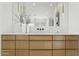 Modern bathroom vanity with dual sinks, sleek fixtures, and custom cabinetry for ample storage space at 6147 E Desert Cove Ave, Scottsdale, AZ 85254