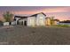 Modern home boasting a sleek design, multiple garage doors, desert landscaping, and a beautiful dusk sky at 6147 E Desert Cove Ave, Scottsdale, AZ 85254